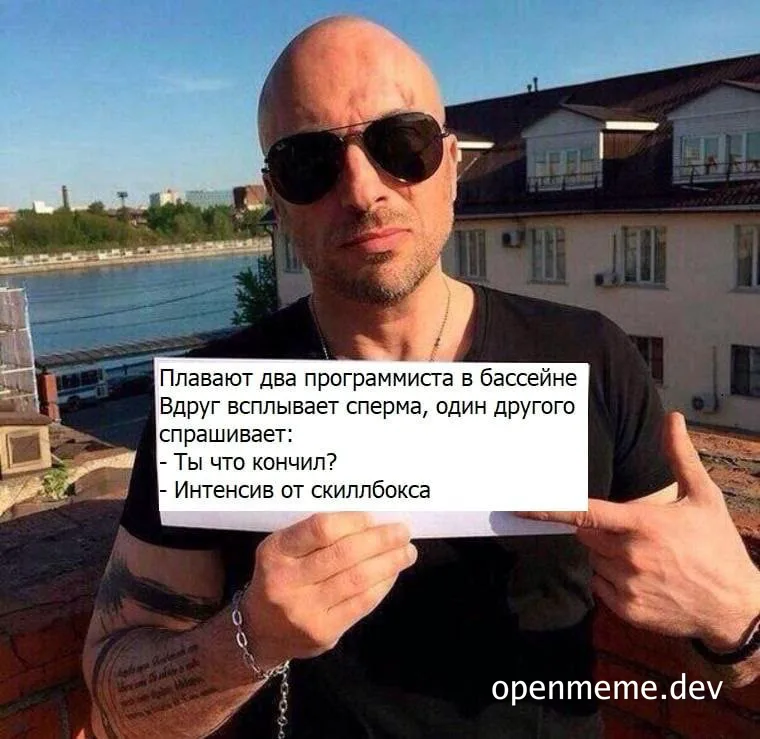 Man holding a sign with russian text about programmers