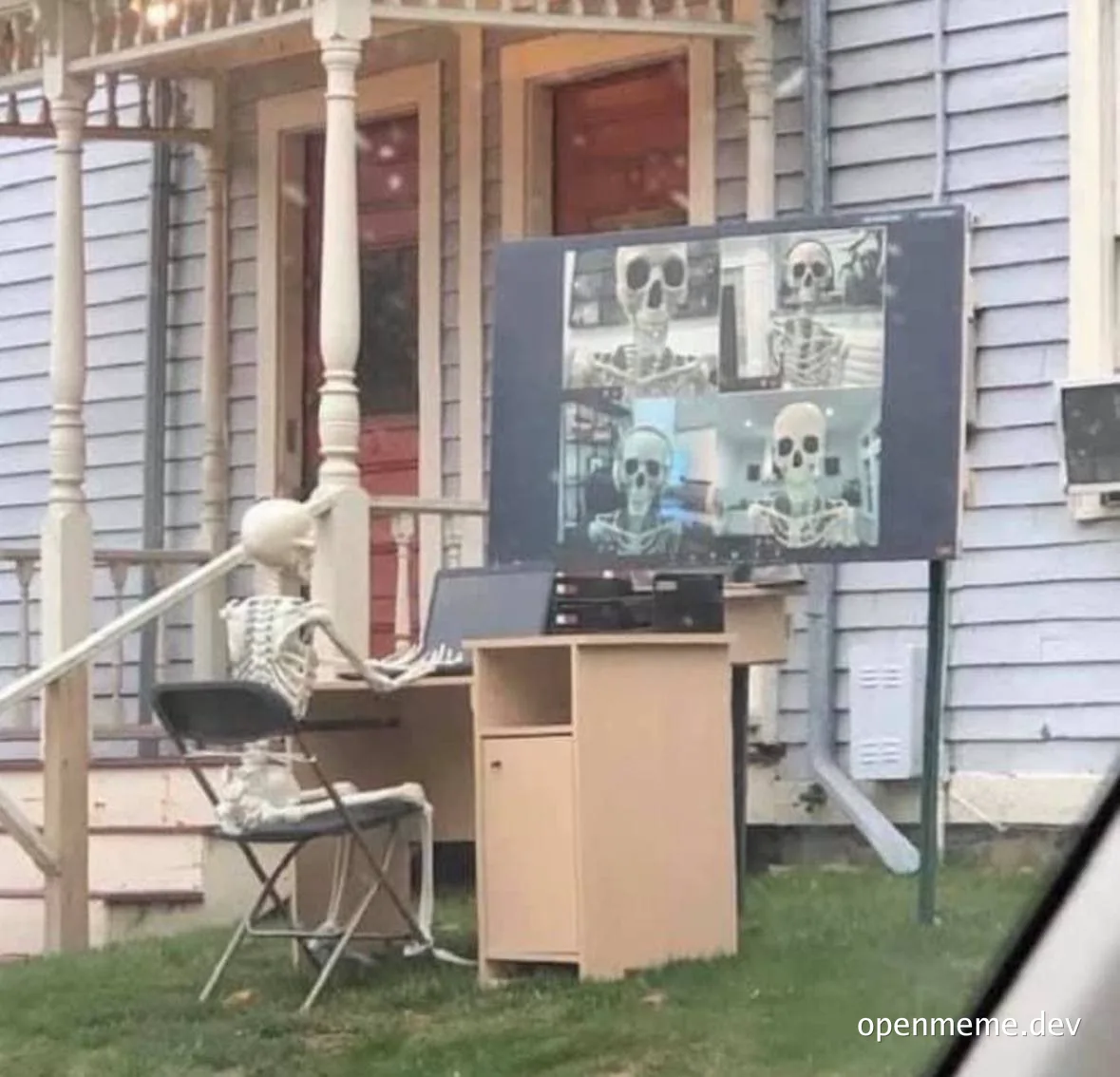 a skeleton sitting at a desk with a laptop and monitor displaying other skeletons on video calls