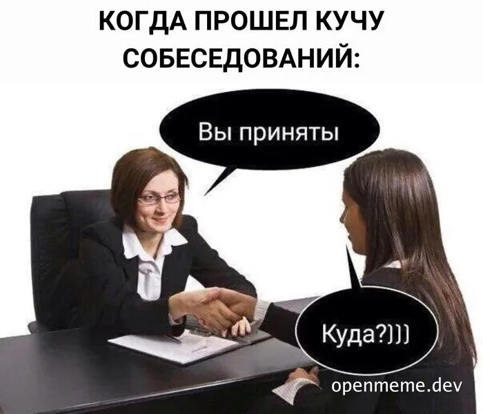 Two women in business attire shaking hands at a desk with a surprised expression