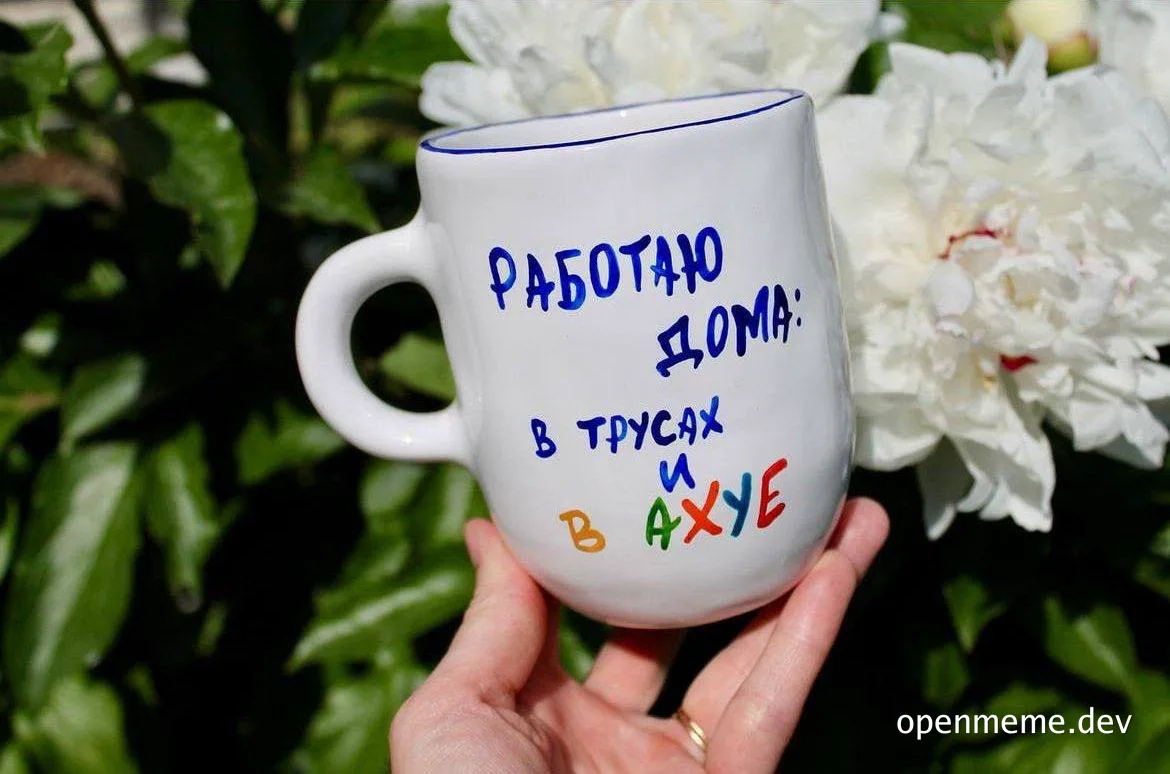 hand holding white mug with russian text