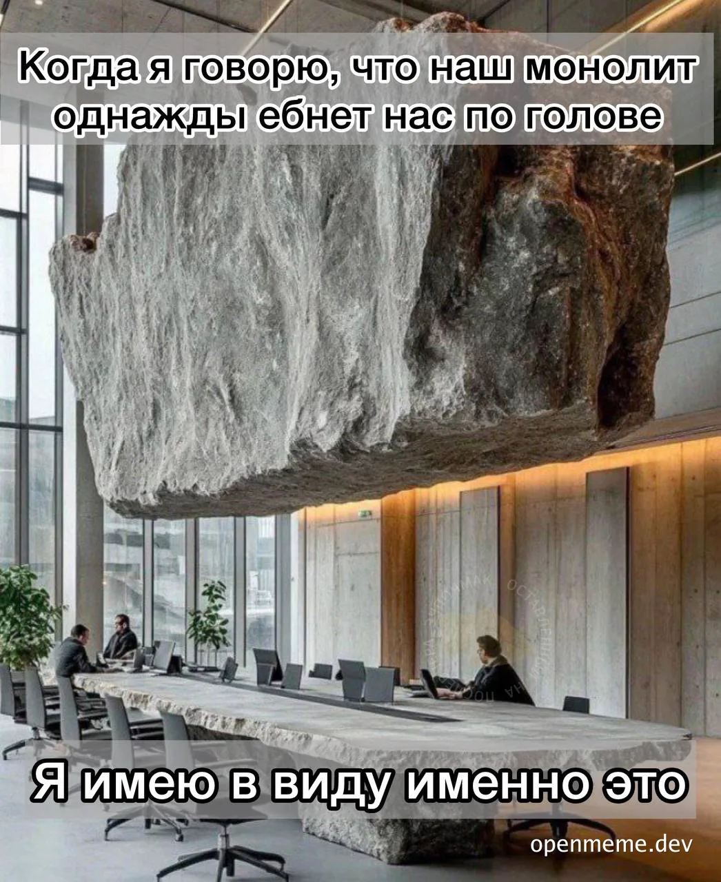 A large rock suspended over a conference table with people sitting at it