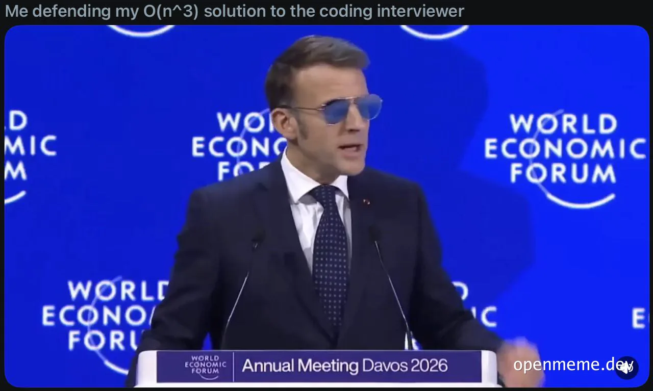 Man in suit and sunglasses at podium with World Economic Forum backdrop