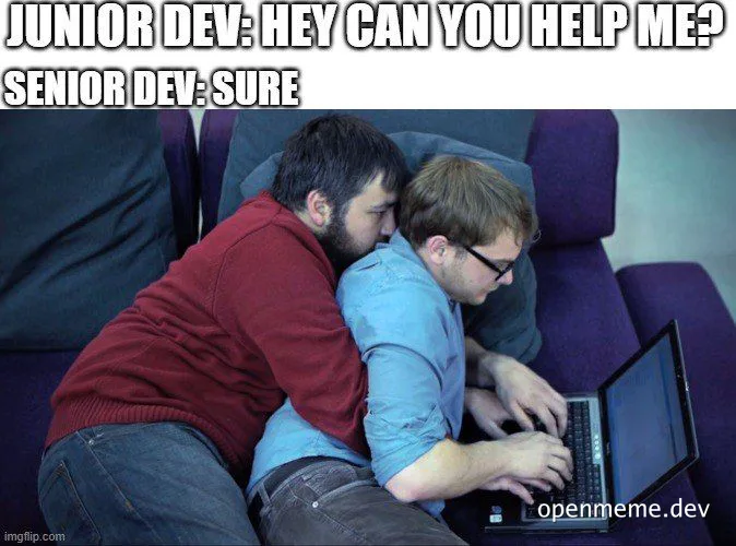 Two developers sitting on a couch, one leaning on the other, looking at a laptop