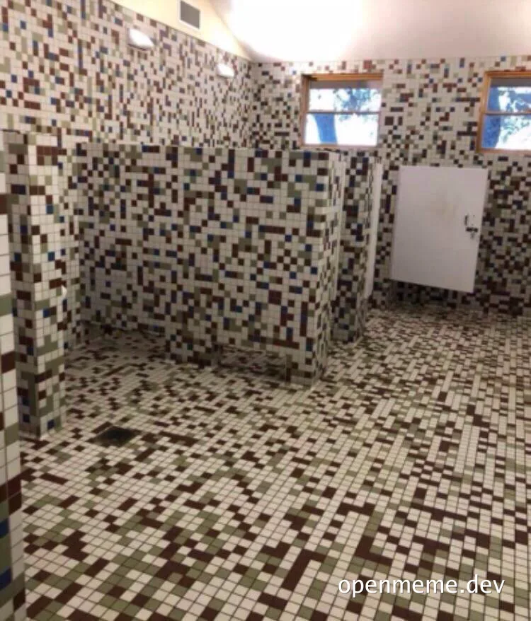 A bathroom with walls and floor covered in mosaic tiles arranged to look like a pixelated 8-bit map.